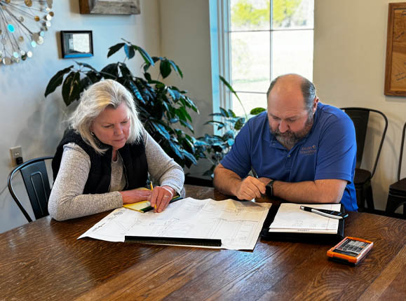 Two People At Joseph Remodeling Solutions Writing on a Desk
